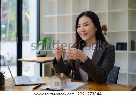 Business woman or Agent giving house key after signing agreement for buying house. Bank manager and real estate concept.