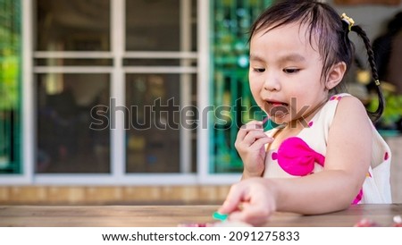 Little cute kid eating chocolate in park. Soft focus. Copy space.