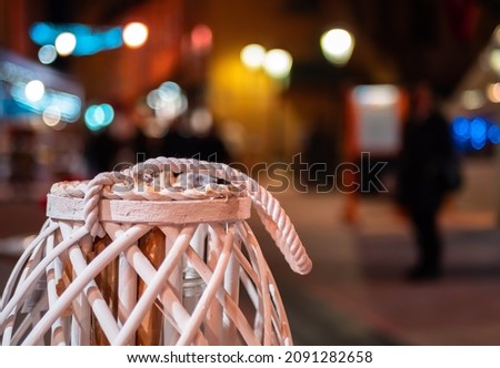 Decorative wooden object with urban illuminated background of defocused and blurred lights, a silhouette of a men on the street