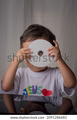 portrait of little boy playing with a computer disk