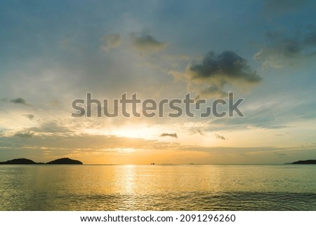 Landscape empty beach island during Sunset.Red purple orange blue pink sunsets over sea and Burning sky and shining golden waves.Sun over sea silhouette paradise island.