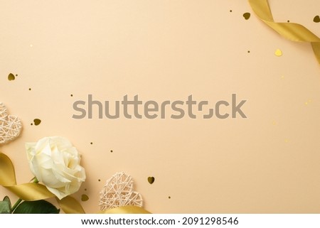 Top view photo of white rose golden silk ribbon sequins heart shaped confetti and rattan hearts on isolated beige background with blank space