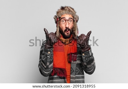 young crazy bearded man. happy and surprised expression and wearing winter clothes