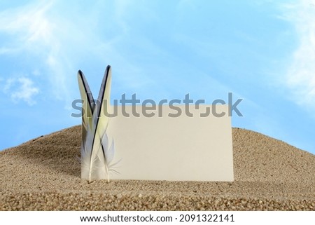 empty business card,greeting card or invitation card with feather mockup in sky and sea sand background