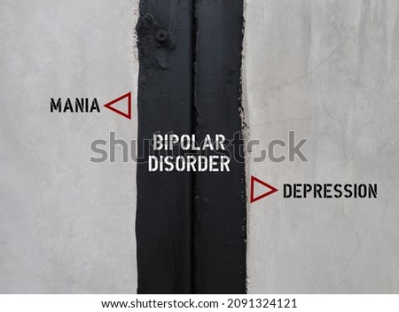 Black and white wall with text BIPOLAR DISORDER , left side MANIA, right side DEPRESSION - concept of mental health extreme mood swings include emotional highs (mania) and lows (depression) Royalty-Free Stock Photo #2091324121
