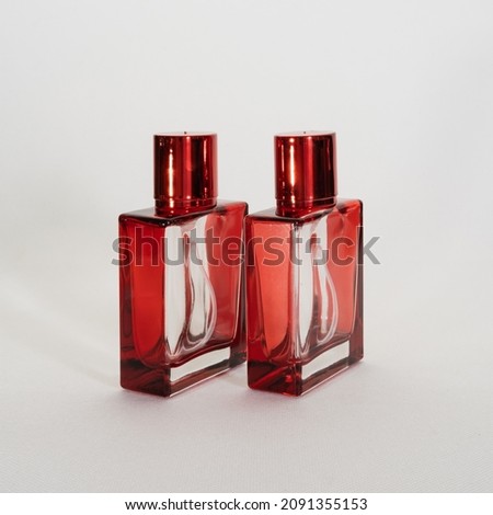 Empty glass container for perfume in a light background.