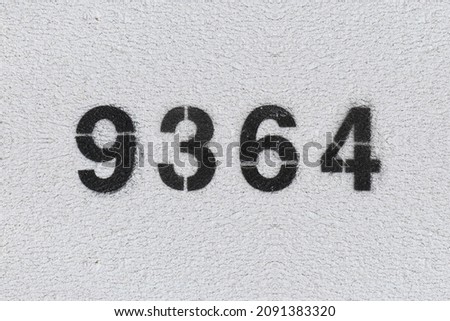 Black Number 9364 on the white wall. Spray paint. Number nine thousand three hundred and sixty four.