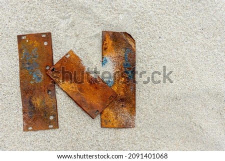 The letter "N" on the sand is made of rusty plates. Metal plates lie on the sandy shore. A letter from the alphabet. Place for the inscription. An unusual letter. Royalty-Free Stock Photo #2091401068