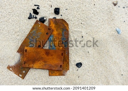 The letter "A" on the sand is made of rusty plates. Metal plates lie on the sandy shore. A letter from the alphabet. Place for the inscription. An unusual letter.