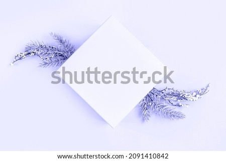Trendy Color of the Year 2022 very peri. Purple background with snowy fir branches and copy space for text. Christmas, festive or winter background. Top view, flat lay, mock up