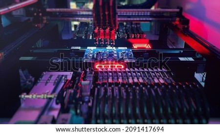 Digital technologies SMT automation industry. Red neon lights illuminate Chip Components for automation test. SMT Concept. Robotic Manipulator arranges electronic microcomponents on a computer board. Royalty-Free Stock Photo #2091417694