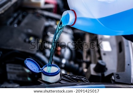 Pouring antifreeze. Filling a windshield washer tank with an antifreeze in winter cold weather.

 Royalty-Free Stock Photo #2091425017