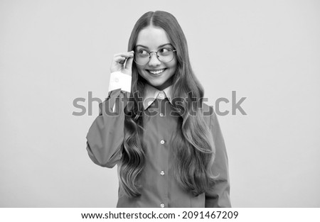 Happy teenage school girl fix eyeglasses smiling yellow background, eyewear