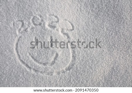 a smile on the white snow in winter and the numbers 2022