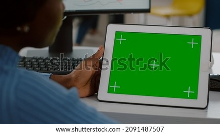 Close up of disabled african worker immobilized in wheelchair looking at digital tablet with green screen chroma key mock up isolated, display comparing graphs from computer working in start up