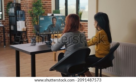 Coworkers using video call on computer to talk to candidate at job interview. Asian women attending remote meeting with applicant on video teleconference to discuss hiring and intern contract.