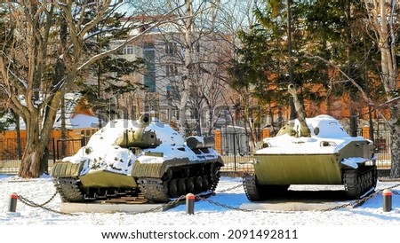 military tanks in the city center against the background of houses in winter in the snow 