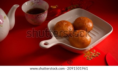 Original tasty Chinese fried buns on a plate and hot tea set. Chinese breakfast or appetizer concept. Translation: Fu meaning good fortune