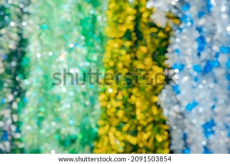 Defocused image of multicolored shiny Christmas tinsel. Background festive picture. Full screen photo. Bokeh optical effect