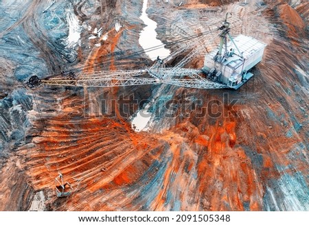 A large walking excavator works in a quarry for the extraction of rare metals. Drone view. Industrial landscape. Royalty-Free Stock Photo #2091505348