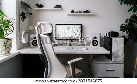 Front view comfortable home office workplace of photographer with computer, camera lens