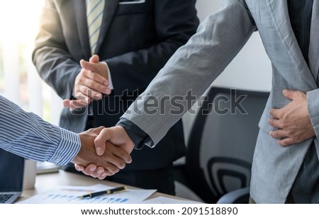businesspeople are shaking their hands after signing a contract at the meeting, close-up. Business communication concept