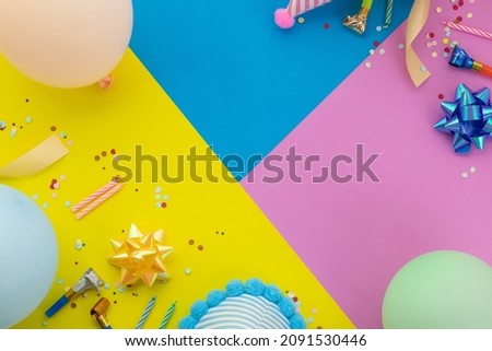 Happy birthday background, Flat lay colorful party decoration on pastel yellow, blue and pink geometric background.