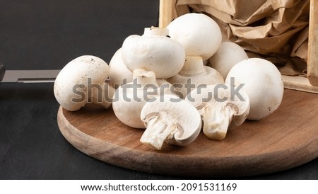Fresh champignon mushrooms on cutting board