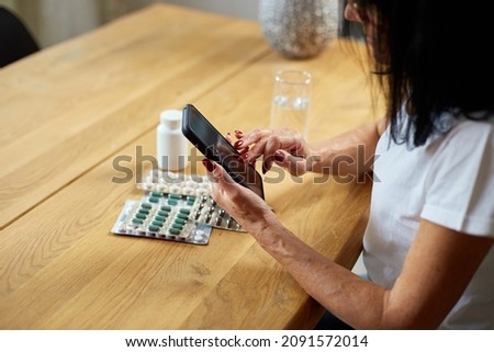 Senior woman reading prescription medication instructions online, swipe scrolling using phone, Doctor and online consultation, Elderly woman checks recipe using her smartphone