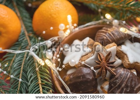 Tangerines and German Christmas pastries, chocolate gingerbread and star-shaped cookies with white icing