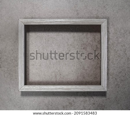Empty Gray Wooden Frame on a Grunge Granite Structure Background ideal for Wall Art, Poster, Decoration. Rough Minimalist Abtract Composition.