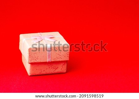 pink gift box on a red background with copyspace. High quality photo