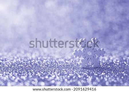 Very Peri toned photo - colour of the 2022 year. Snowflake on blurred background. Selective focus. Macro, minimalism concept. Christmas or winter greeting card, poster. Xmas, Happy New Year holiday