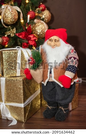 Christmas toy gnome Santa Claus stands under the Christmas tree