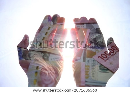 A pair of hands expecting money and wealth. Taken with double exposure technique on camera