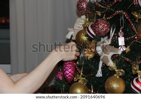 Decorating a Christmas tree with shiny multicolored toys