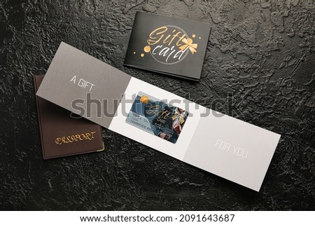 Gift cards and passport on dark background