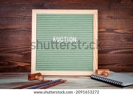 Auction. Office supplies on a wooden table. English text on a letter Board.