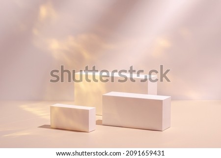 Abstract surreal scene - empty stage with three rectangle white podiums on pastel pink and gold colored background. Pedestal for cosmetic product packaging mockups display presentation Royalty-Free Stock Photo #2091659431