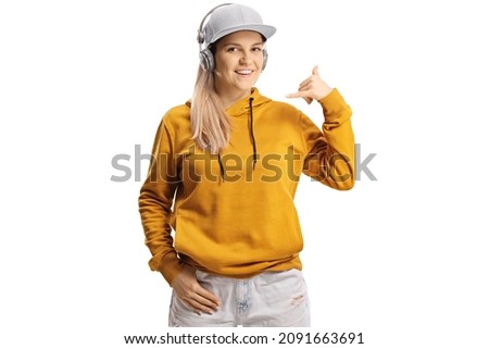 Young female with headphones gesturing a phone call sign isolated on white background