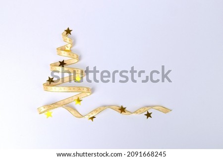 Christmas tree silhouette made with ribbon and golden stars