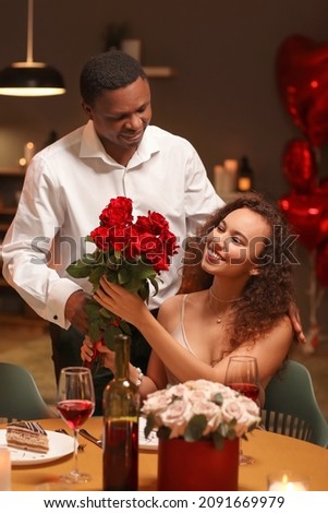 African-American man greeting his girlfriend on Valentine's Day at home