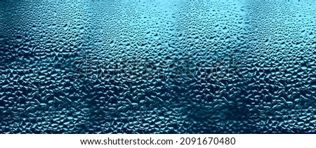 after Rain drops on the window glass. blue sky backdrop. blue  background. condensation on the transparent glass. 