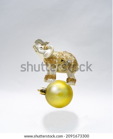 a golden Asian elephant standing on a New Year’s  golden ornament. It's like floating in the air with a gentle white background