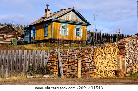 An old village house with a woodpile in Russia Royalty-Free Stock Photo #2091691513