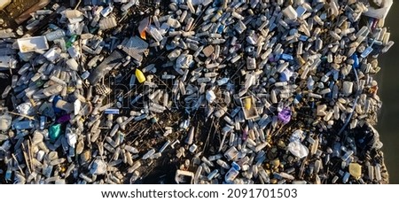 Aerial shot view waterfront scrap-heap pile plastic bottles rubbish outdoor. Pollution debris on lakeshore. Global damage, environmental pollution concept. Costa Blanca. Guardamar del Segura. Spain