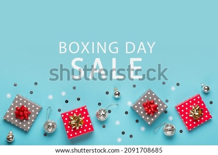 Boxing Day Sale promotion composition background. Christmas Shopping, Offer, Sale Concept. Holiday decorations and festive gift boxes on pastel blue background. Flat lay, top view, copy space.  Royalty-Free Stock Photo #2091708685