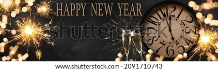 HAPPY NEW YEAR 2022 - Silvester New Year's Eve Party celebration background panorama banner long - Golden yellow fireworks, sparklers, clock and champagne classes toasting in the dark black night