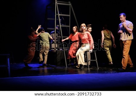 Actors and actresses perform a modern performance on the black stage of the theater. Royalty-Free Stock Photo #2091732733