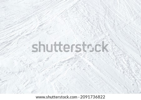 Top view of white ski tracks on snow background.